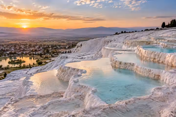 Pamukkale’s white travertine terraces and turquoise water in warm morning light