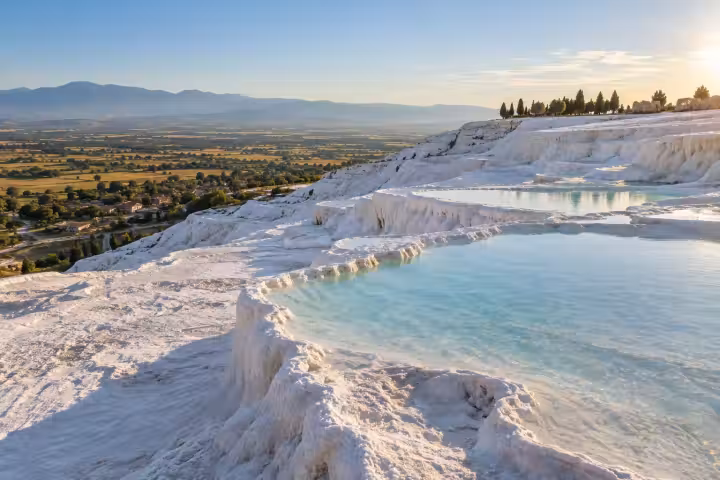 Pale aquamarine pools and white travertine ledges above the Pamukkale valley