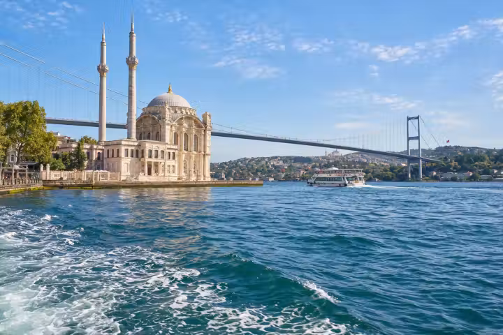 Ortakoy Mosque, the Bosphorus bridge and a passing boat seen from the water