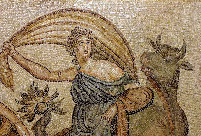 Fine tesserae in amber and grey: a veiled figure at the shoulder of a bull, Zeugma