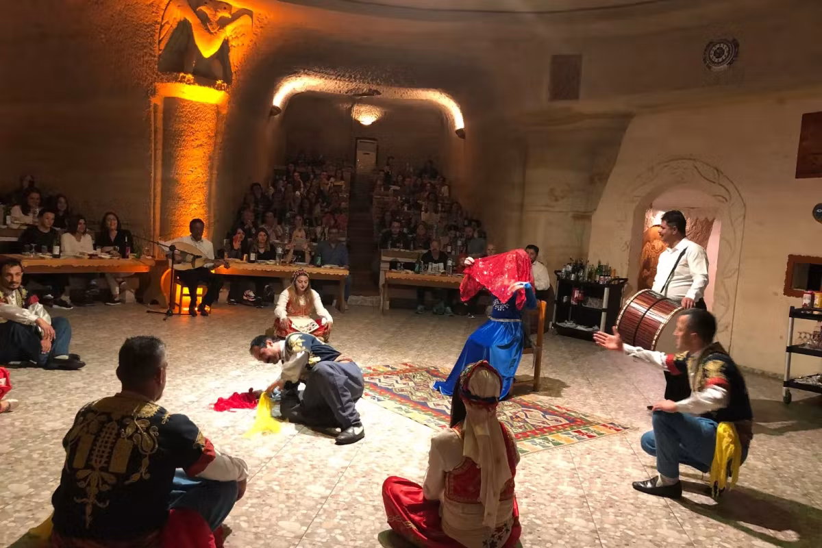 Guests ringing the boards in a carved Cappadocia venue as the troupe and drum take position