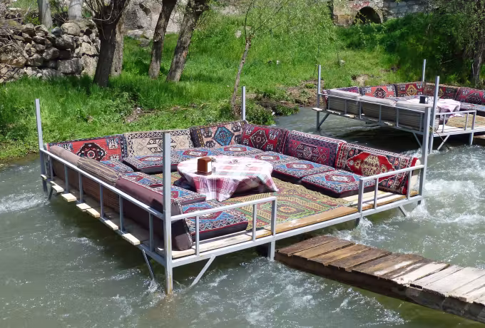 Rug-topped platforms standing in the shallows at Belisirma, a short gangway out to them