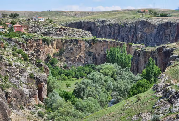 Deep green cut driven through the tableland at Ihlara with houses right on the brink
