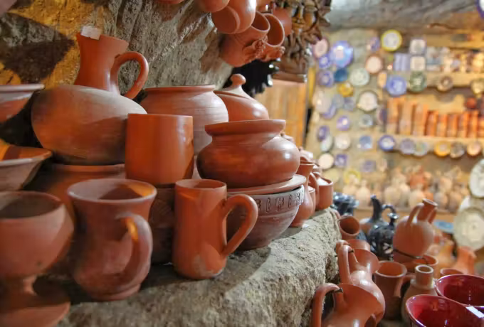 Unglazed jugs, beakers and pitchers piled on masonry outside a workshop, plates behind, Cappadocia