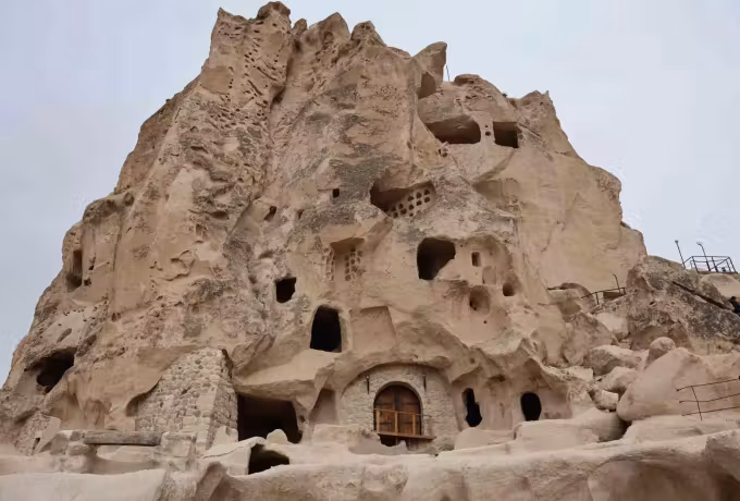 Tight frame of the outcrop showing hollowed cells, entries and stairs in weathered stone, Cappadocia
