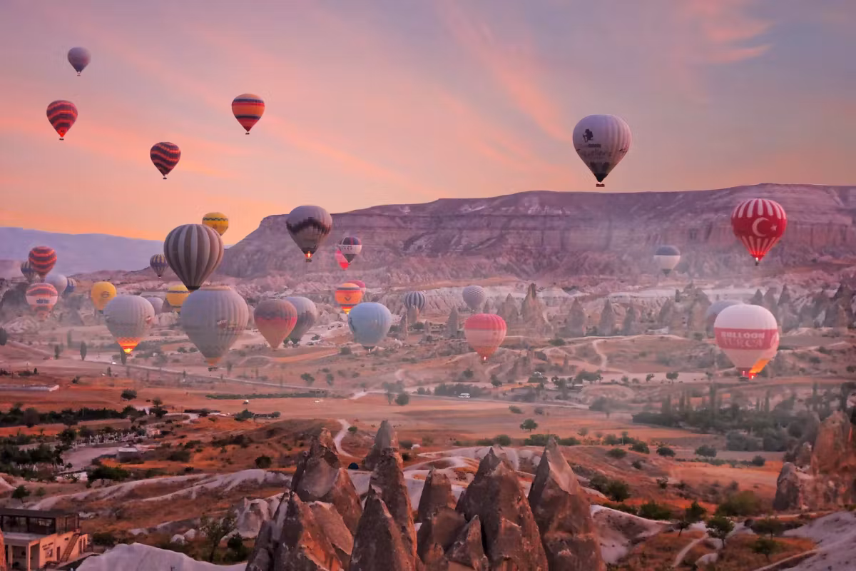 Every colour packed into the air just off the valley floor, pink streaks over the ridge, Cappadocia