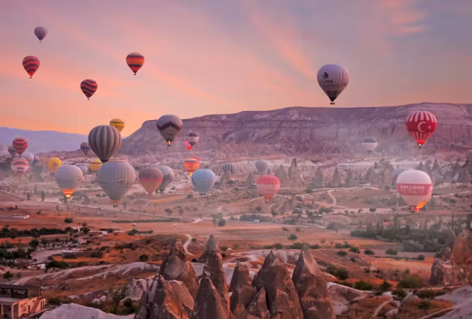 Every colour packed into the air just off the valley floor, pink streaks over the ridge, Cappadocia