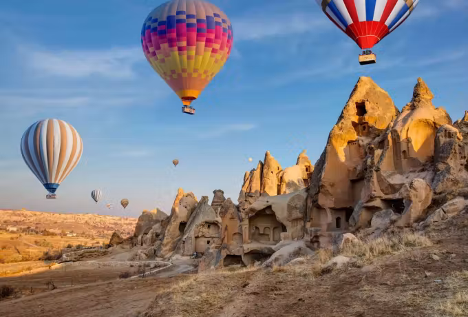 Two banded envelopes passing just clear of jagged worn rock on a bright morning, Cappadocia