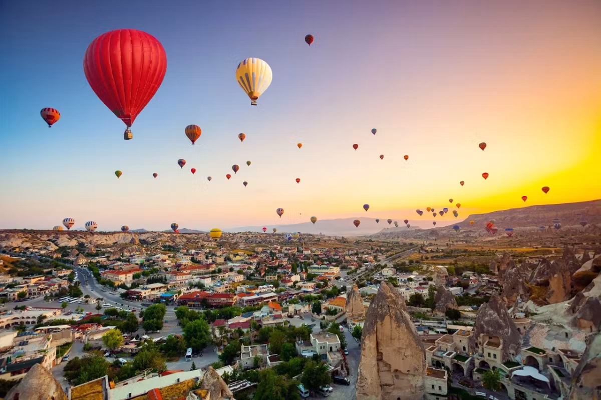 One huge scarlet canopy above Goreme with the rest of the flight fading into orange air