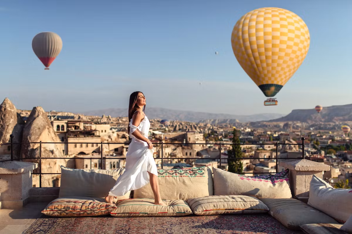 Long ivory skirt on a bolstered terrace as gold fabric slides by within touching distance, Cappadocia