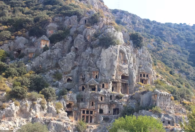 Tomb openings set at every height across the pale hillside of the necropolis at Myra