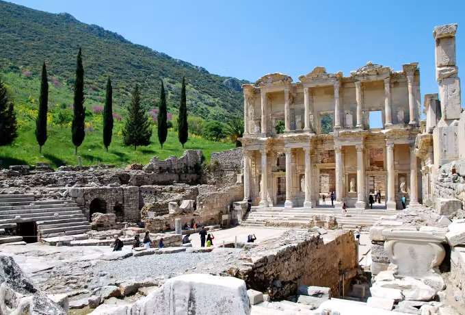 Dark conifers and a green bank enclosing the great elevation above its broad paved court, Ephesus