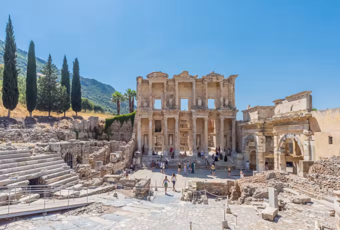 Oblique from the auditorium benches at Ephesus to the Celsus front, cypresses on the slope
