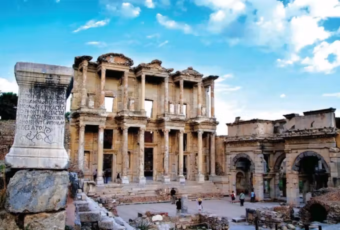 Lettered marble post in front, the Celsus elevation and Roman arch standing behind it, Ephesus