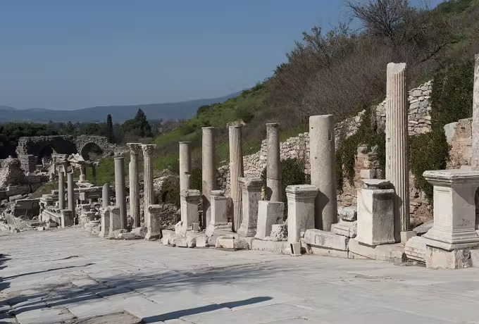 Uprights left at every height along the wide slabbed processional way in bright spring air, Ephesus