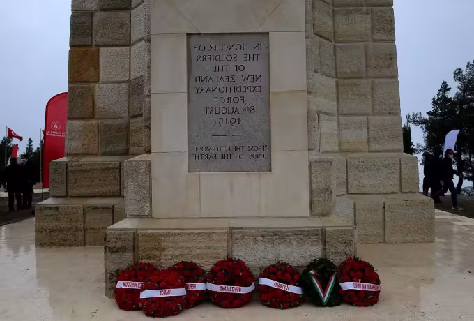 Circles of poppies left where a lettered slab honours the New Zealand dead, Gallipoli