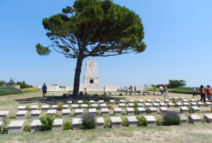 People walking between the plots at Lone Pine, the wide tree alongside the monument, Gallipoli