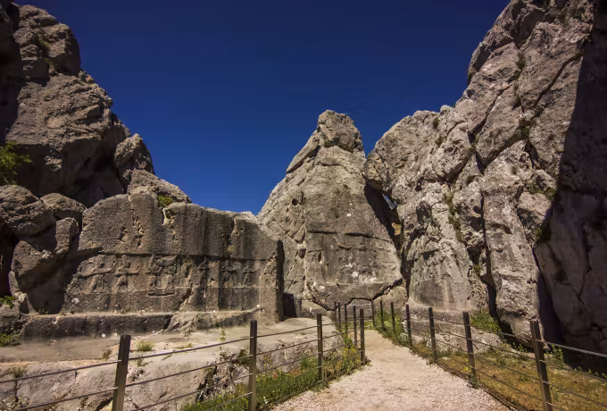 Squeezed passage in the rock, one flank bearing a band of striding divine figures, Hattusa