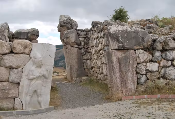 Pale cast of the armed divinity standing alongside the doorpost it was taken from, Hattusa