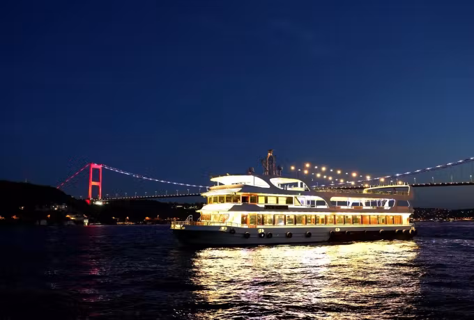 Glowing span overhead as a lit vessel makes its night crossing of the dark Bosphorus