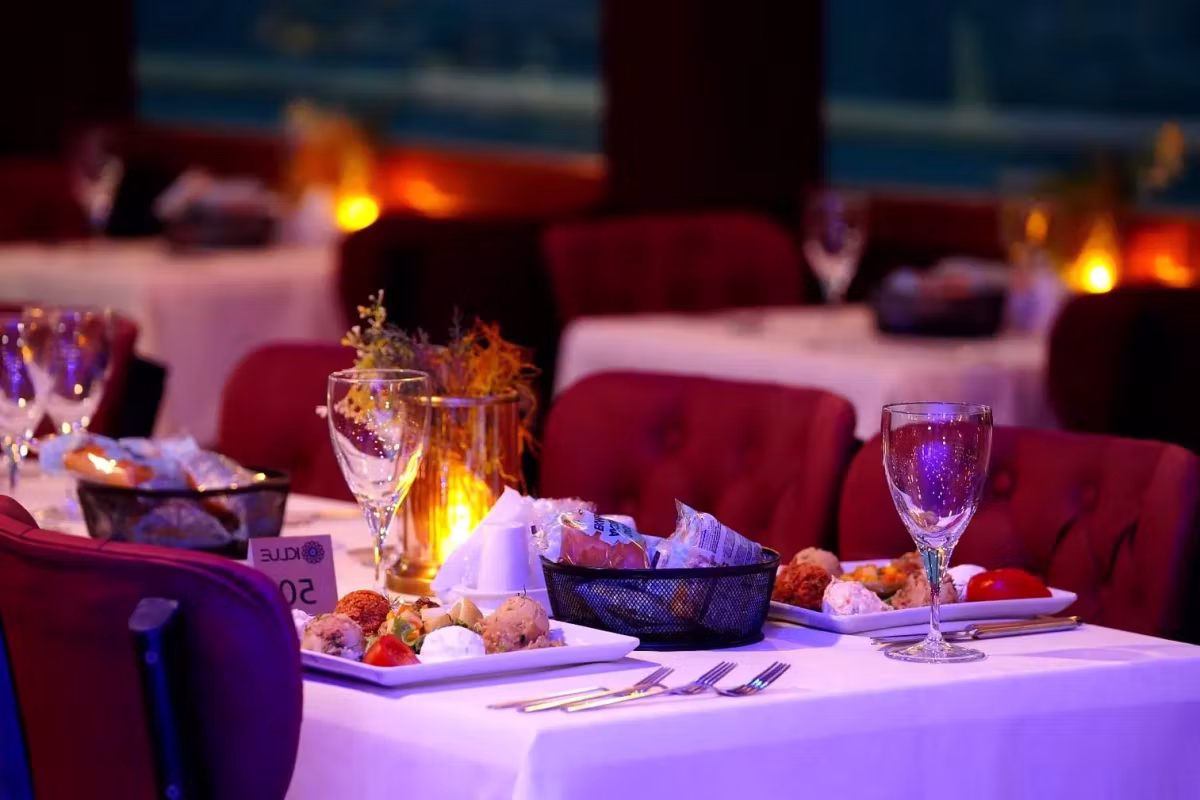 Candlelight over an untouched cover of small plates and glasses, Bosphorus cruise