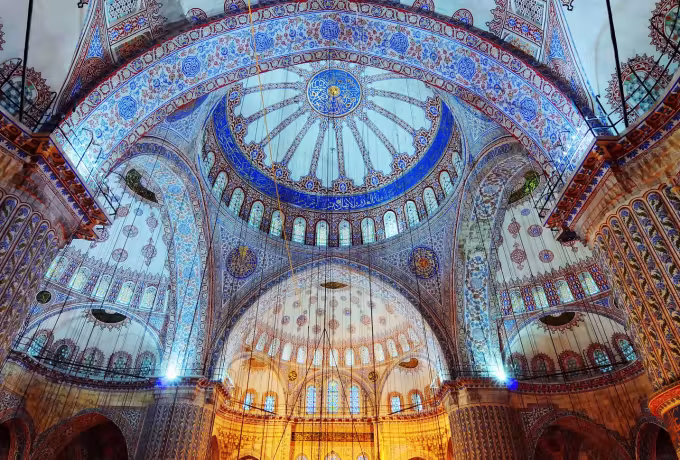 Looking straight up into a main cupola and its half-domes, blue and white tiles throughout