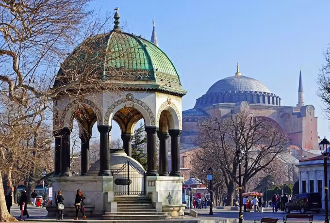 Verdigris cap of the Sultanahmet drinking kiosk set against the enormous church behind