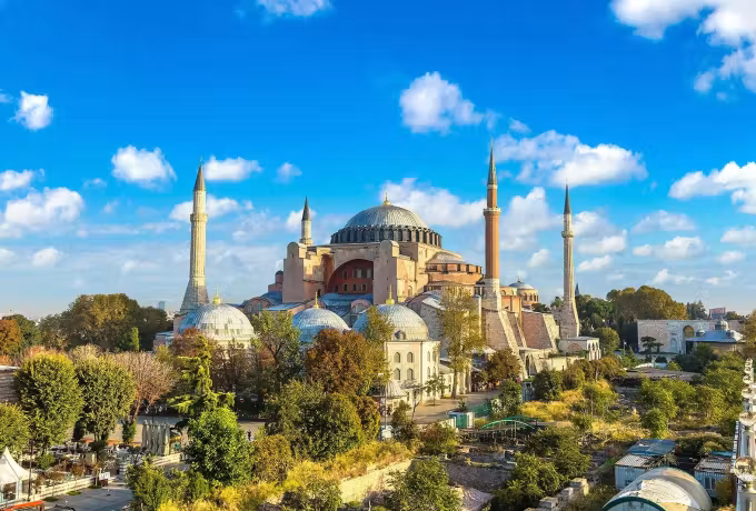 Whole building under clear autumn sky, leaded cupola ringed by smaller ones and four towers, Istanbul