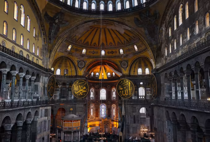Enormous nave opening toward the apse, huge lettered roundels hung beneath the gilt cupola, Istanbul