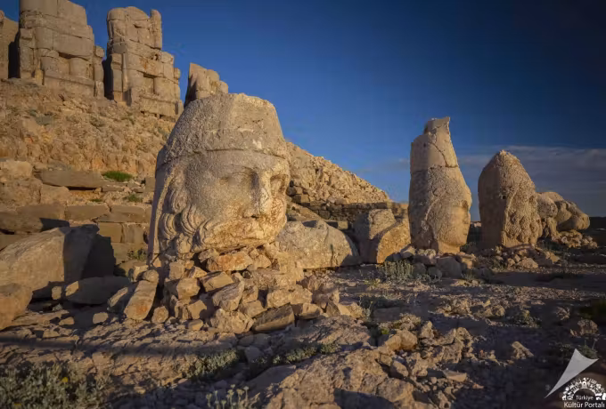 Low sun cutting sideways across a diadem and tight curls on the eastern platform, Mount Nemrut