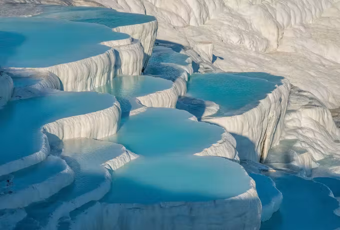 Blue water in the white travertine pools at Pamukkale