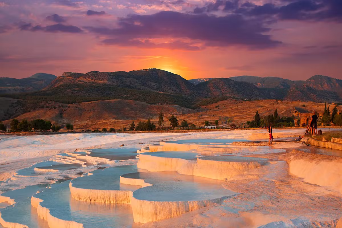 Mauve and amber piled over the upper slope with the last glow caught on the rims, Pamukkale