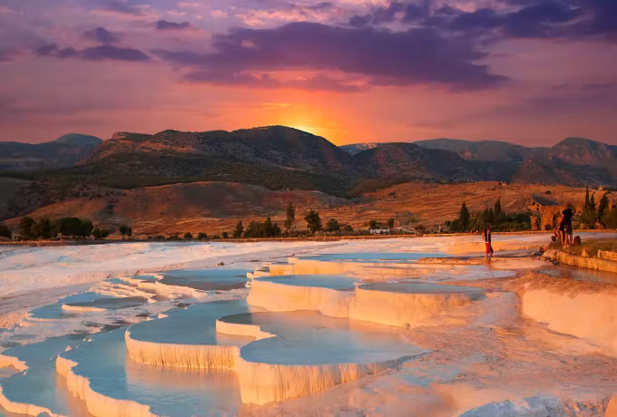 Mauve and amber piled over the upper slope with the last glow caught on the rims, Pamukkale