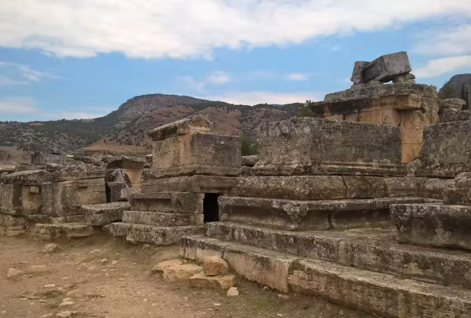 Lintelled burial chamber among loose blocks on the dry ground of the Hierapolis cemetery
