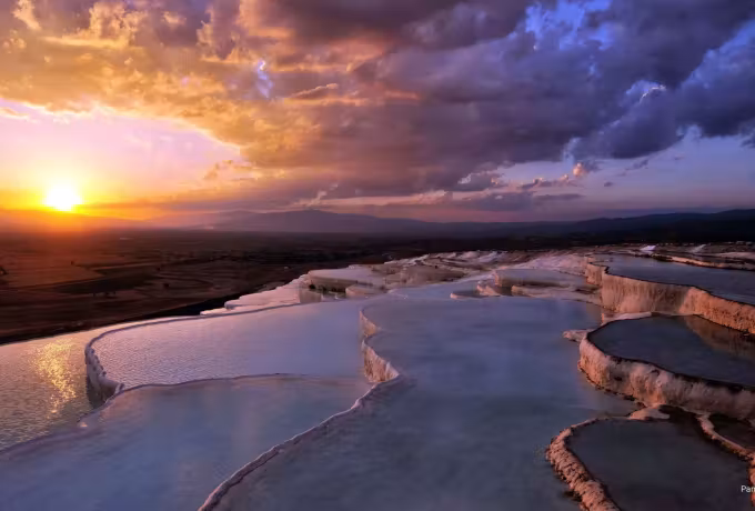 Daylight finishing past the mineral steps as purple weather opens out overhead, Pamukkale