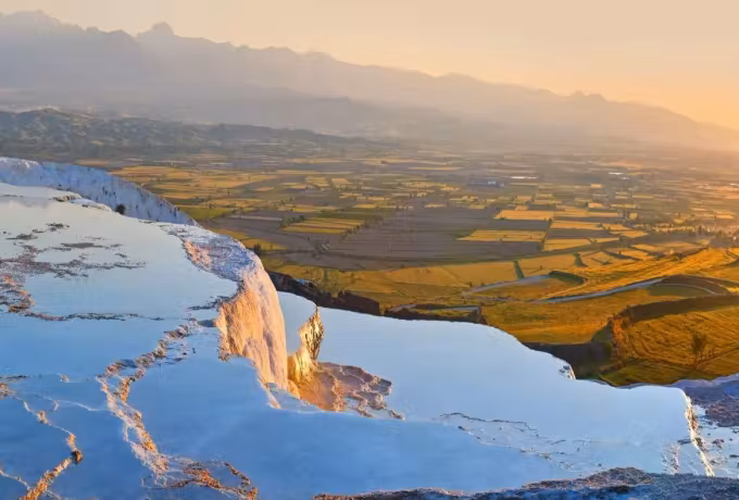Light catching the chalk lip above the wide gold cropland of the plain at Pamukkale