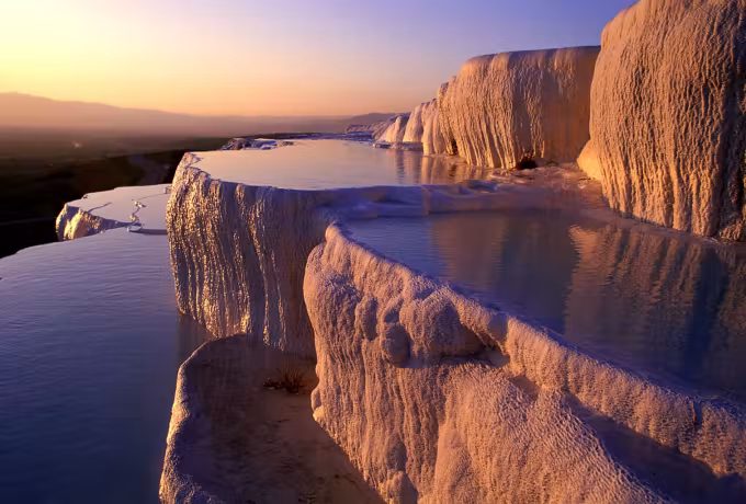 Lime faces taking the last warm light while vapour drifts off the water below, Pamukkale