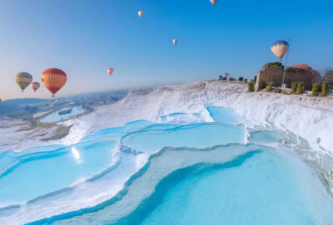 Envelopes crossing above bright blue basins with a ruined tower up on the crest