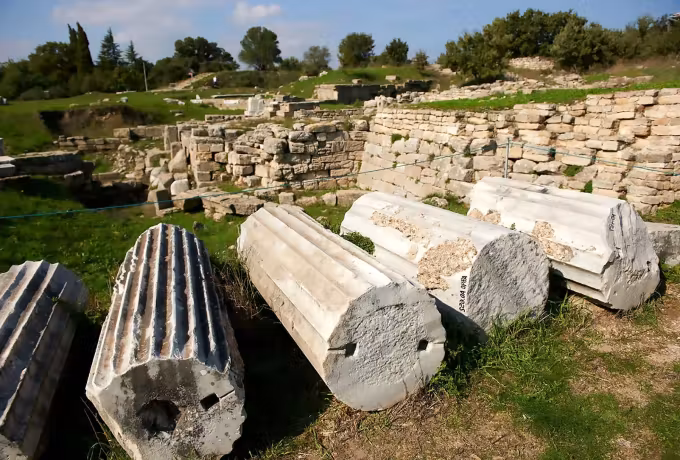 Grooved marble sections lying where they fell, next to a wall line on the Troy site