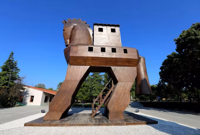 Reddish timber figure at the Troy gate, a stair let into it so visitors can climb inside