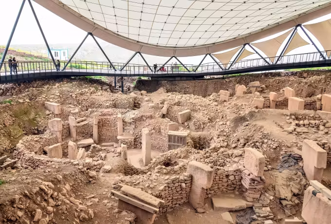 White cover stretched over the Gobeklitepe field, chambers and uprights at different stages