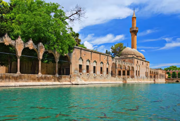 Ornate arched front of Halil-ur Rahman running along the vivid water at Balikligol