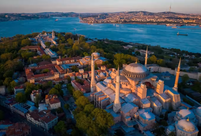 Drone pass over Sultanahmet with the great church among roofs and the channel opening behind