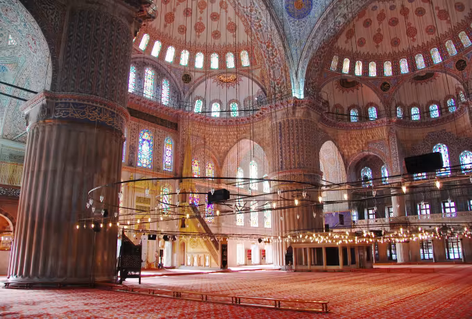 One enormous ribbed support standing next to carpeting beneath tiled arcading, Istanbul