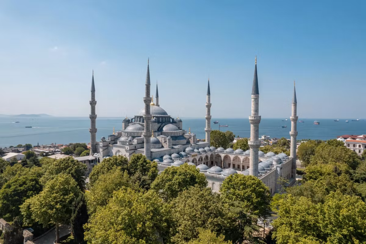 Roofline above public gardens with the washed-out Marmara stretching to the horizon