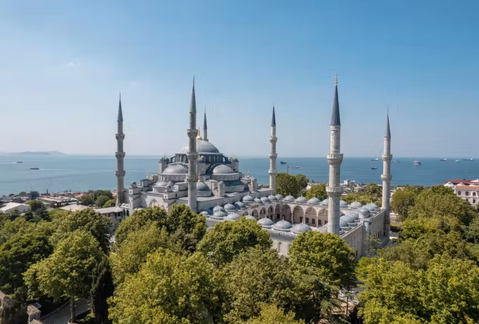 Roofline above public gardens with the washed-out Marmara stretching to the horizon