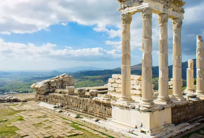Rebuilt row of columns at the Trajaneum standing on its terrace over wide green country, Ephesus