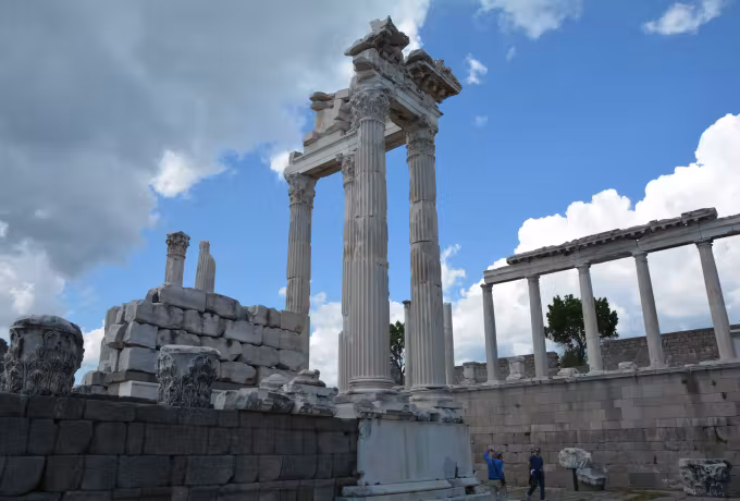 Reassembled elevation of the Trajaneum standing clear of a sky heaped with white, Ephesus