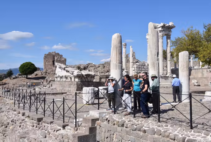 Party pausing between shafts and fenced trenches on the height at Pergamon