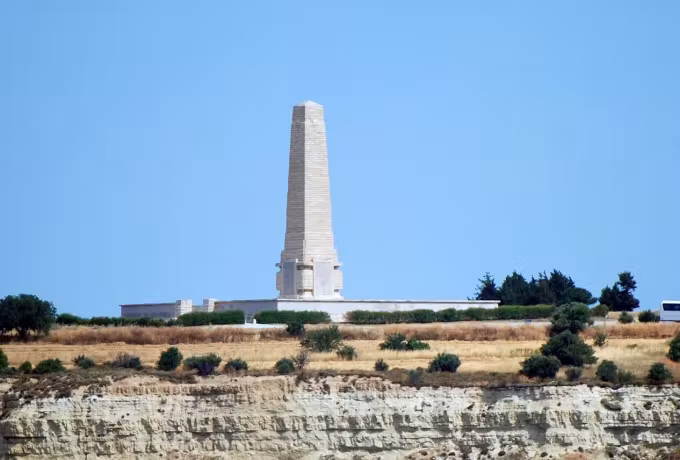 Pillar at Cape Helles standing over banded sea cliffs at the end of the peninsula